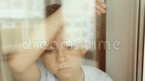 一个悲伤的孩子望着窗外视频的预览图