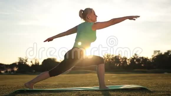 成年健康女性在日落时练习瑜伽视频的预览图