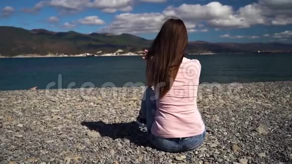 女孩坐在海滩上视频的预览图
