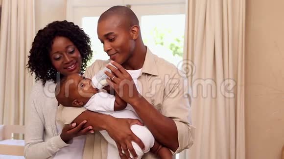 快乐的父亲喂婴儿和母亲视频的预览图