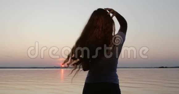一个年轻的女人在日落时跳舞视频的预览图