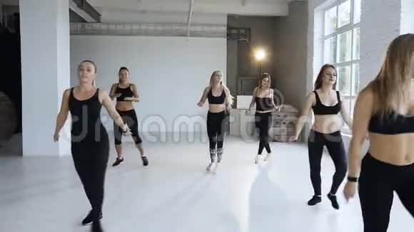 一群年轻的运动女孩带着健身教练在大厅里进行锻炼健身训练体育女孩视频的预览图