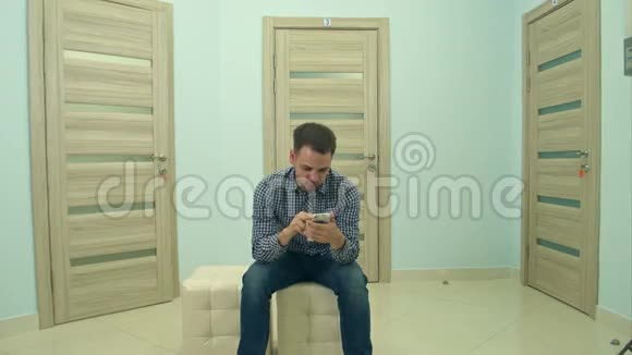 男性病人在等待医生预约时使用电话视频的预览图