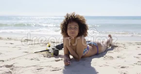 女人用脚蹼躺在海滩上视频的预览图