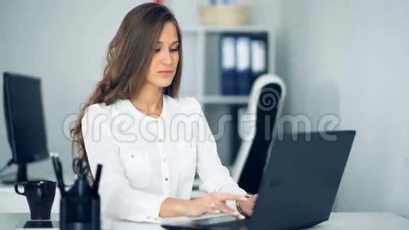 微笑的女商人用她的笔记本电脑办公视频的预览图