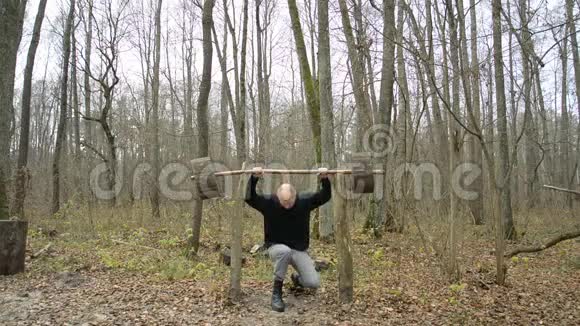 他正和一个杠铃坐在森林里视频的预览图