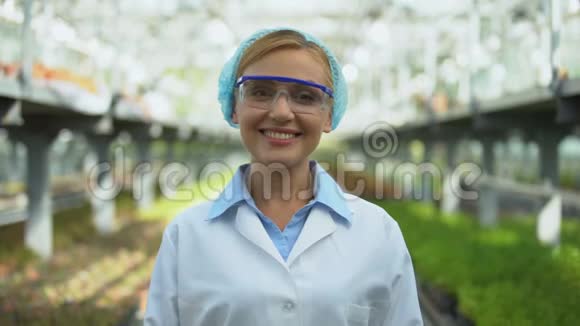 友好的女科学家在温室里对着镜头微笑育种研究视频的预览图