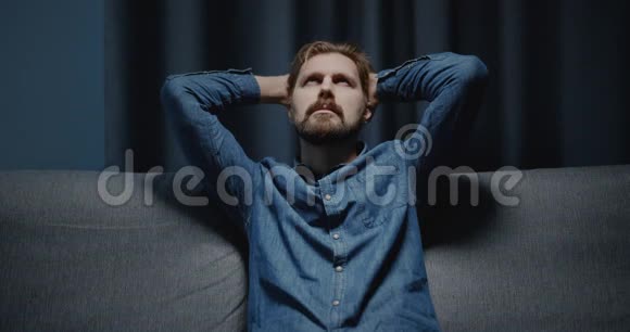 沮丧的男人坐在沙发上视频的预览图