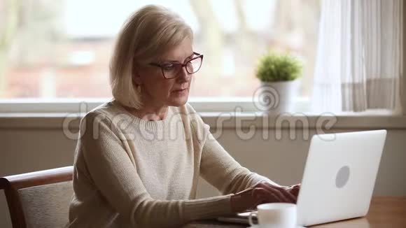 使用笔记本电脑的老年妇女感到不适摘下眼镜视频的预览图