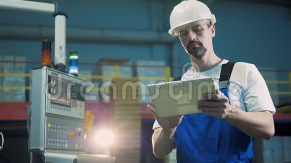 工厂工人在平板电脑上打字站在设施房间里视频的预览图