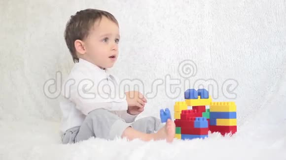 快乐的孩子在沙发上的彩色积木里玩耍视频的预览图