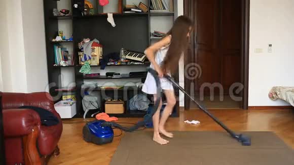 女孩用吸尘器打扫房间里的地毯视频的预览图