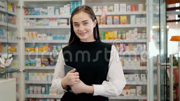 从事数字片剂和药品药房工作的女药师剂师幸福女子药店肖像顾问视频的预览图