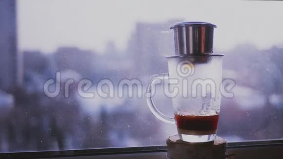 咖啡滴在杯子里洒在窗外城市景观的背景上用越南语酿造咖啡慢慢视频的预览图