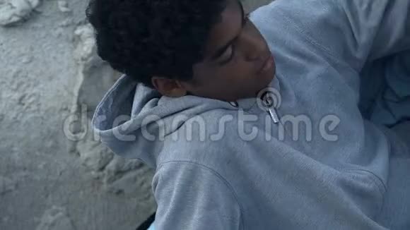 街头躺在睡袋里的黑人少年离家出走遇到问题视频的预览图
