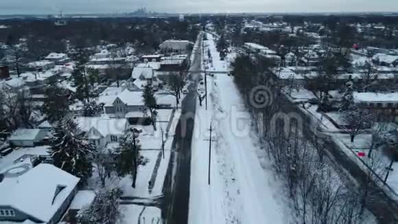 冬天寒冷的一天一个被雪覆盖的小镇上的铁轨的鸟瞰图视频的预览图