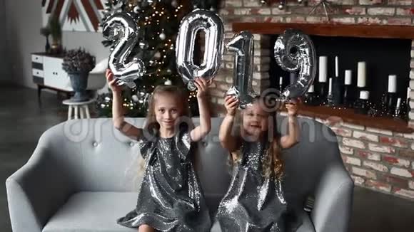 两个微笑的小女孩牵手新年气球编号2019圣诞节新年概念视频的预览图
