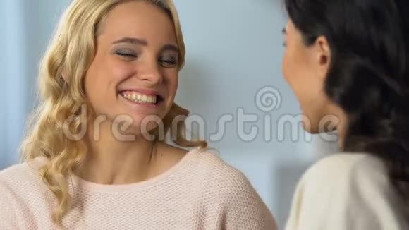 微笑的女孩拥抱她的黑发朋友庆祝好消息友谊视频的预览图