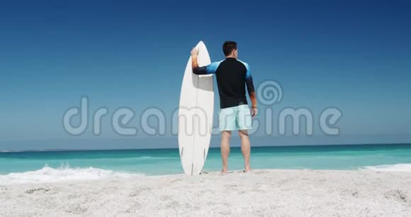 在海滩上拿着冲浪板的人视频的预览图