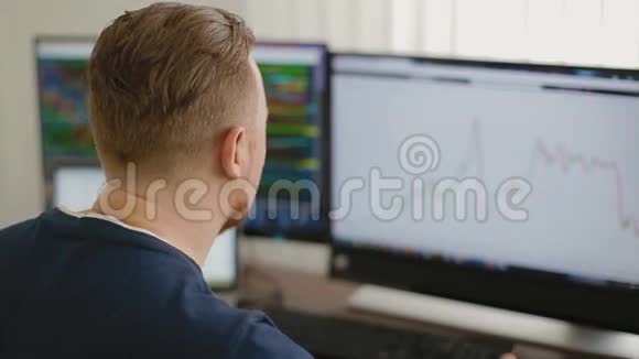 程序员在3台显示器后面的办公室工作视频的预览图