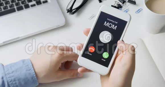 接到妈妈的电话并接受移动通信概念坐在书桌前视频的预览图