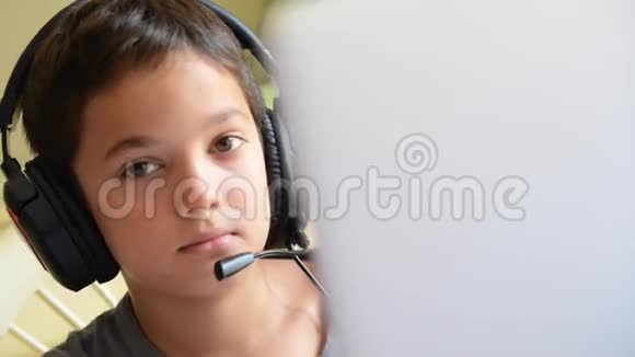 儿童开心地听音乐在电脑上用耳机在户外播放视频的预览图