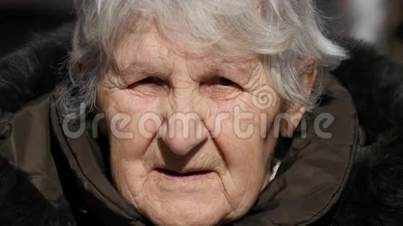 年轻的女孩和成年的女人亲吻祖母的脸颊奶奶微笑着看着相机视频的预览图