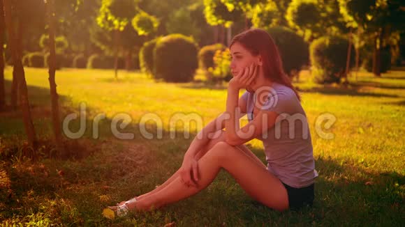 伤心的女人坐在绿草上视频的预览图