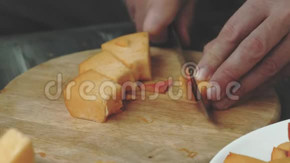 一个男人切一个橙色的南瓜视频的预览图
