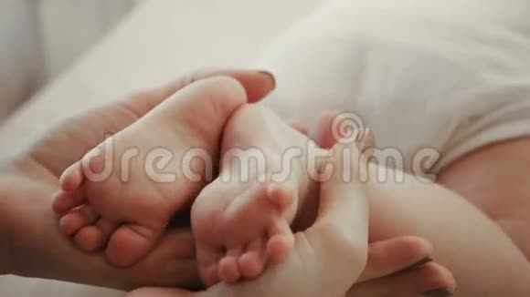 宝宝脚在妈妈手里小新生婴儿的脚在女性心脏整形的手特写妈妈和她的孩子快乐视频的预览图