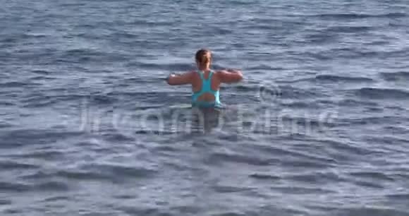 穿蓝色树干游泳的女人视频的预览图