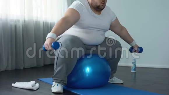 虚弱的肥胖男性奋力举起哑铃缺乏体力活动饮食视频的预览图