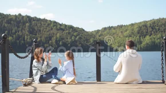 秋天和女儿在池塘钓鱼的幸福家庭视频的预览图