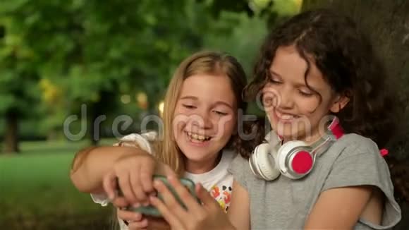 两个小女生用智能手机孩子们在玩看书看电话人儿童技术视频的预览图