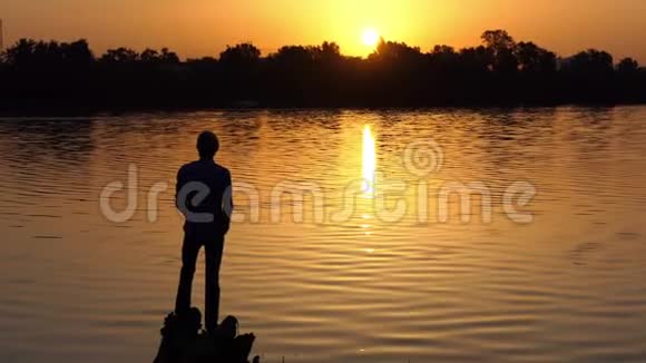 梦想中的人站在湖边的树根上视频的预览图