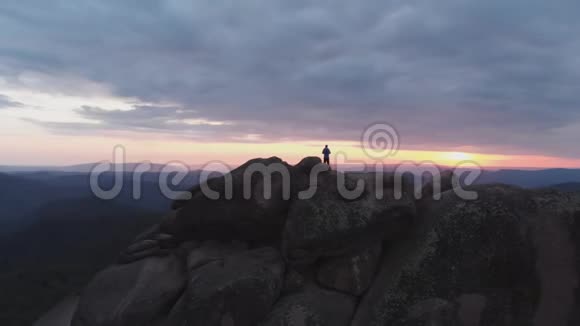 俯瞰孤独的人站在悬崖上欣赏日落视频的预览图