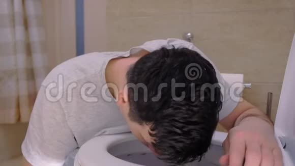 坐在地板上宿醉的厕所里恶心呕吐的人的肖像视频的预览图