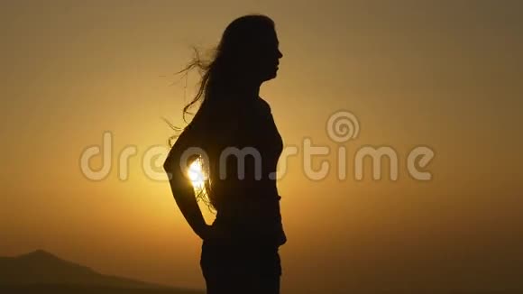 女人站在夕阳下背光视频的预览图