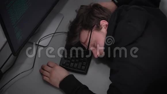 信息技术学院的一名年轻学生在电脑显示器的打印版上睡觉视频的预览图