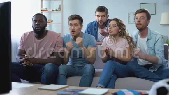 多民族朋友在家看足球比赛庆祝进球视频的预览图