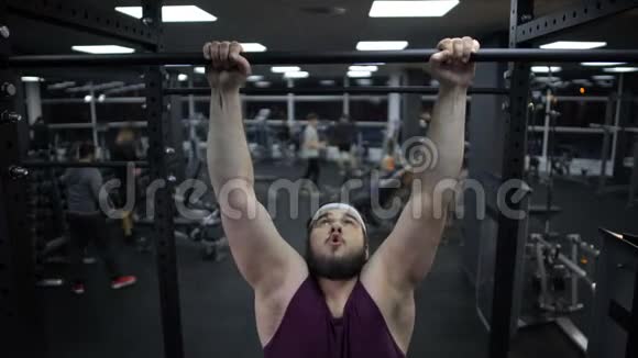 超重男子试图在运动杆上拉起来身体肌肉无力健身房训练视频的预览图