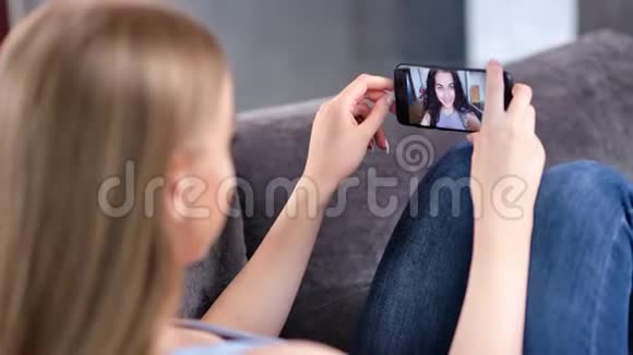两个快乐的年轻女人一起享受视频网络摄像头用智能手机特写聊天视频的预览图