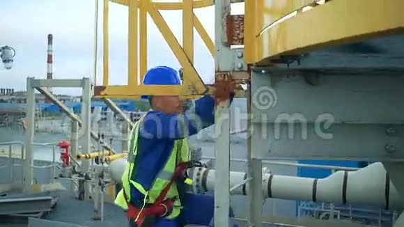 一位亚洲工程师攀登一座大型炼油厂的塔视频的预览图