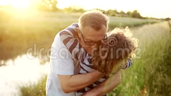 一个成熟的男人拥抱抚摸他的头亲吻他已故的孩子可爱的卷发男孩家庭假日幸福家庭视频的预览图