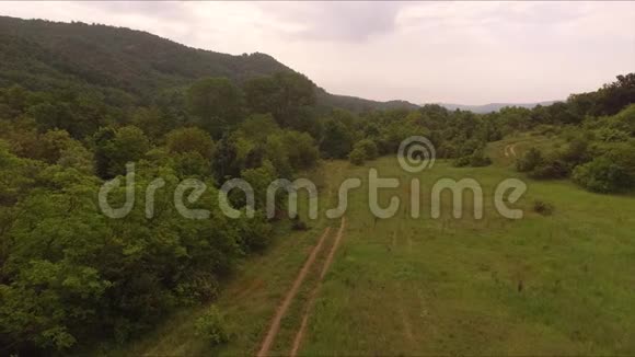 飞过群山树林和草地之间的土路视频的预览图