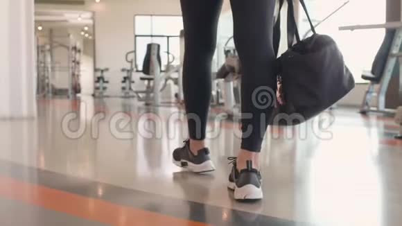 在健身运动俱乐部健身房里行走准备进行肌肉重量训练的亚洲女性腿部特写人民视频的预览图