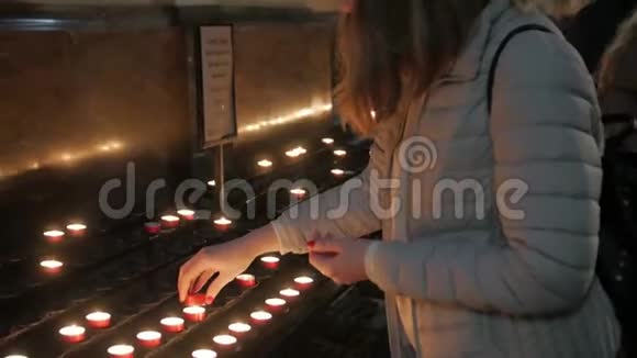 女孩点亮教堂的蜡烛视频的预览图