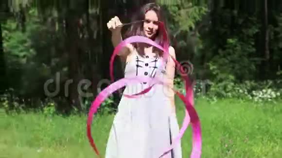 穿着裙子的女孩回到森林扭着粉红色的丝带视频的预览图