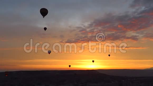 日出时热气球飞越卡帕多西亚上空的剪影视频的预览图