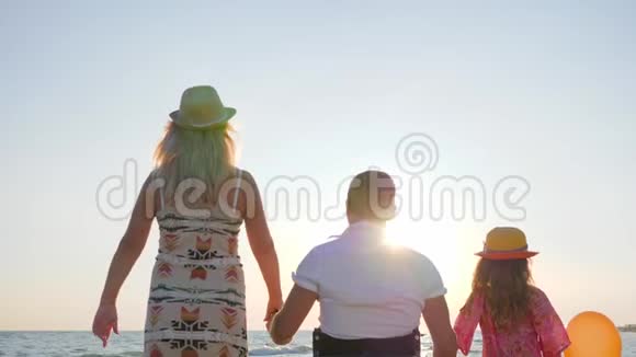 妻子和女儿在海边举起五颜六色的气球一家人带着孩子这是无效的视频的预览图